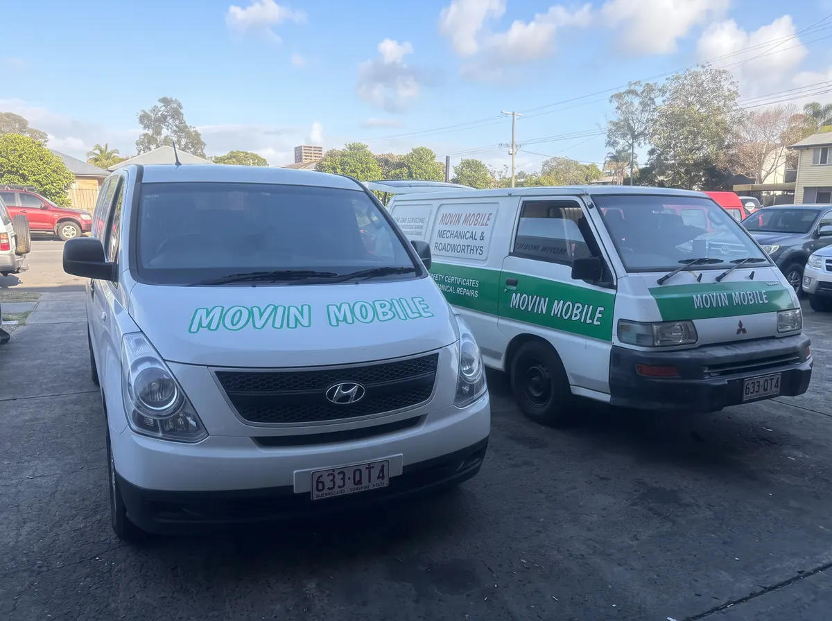 Two white and green Movin Mobile service vans parked side by side