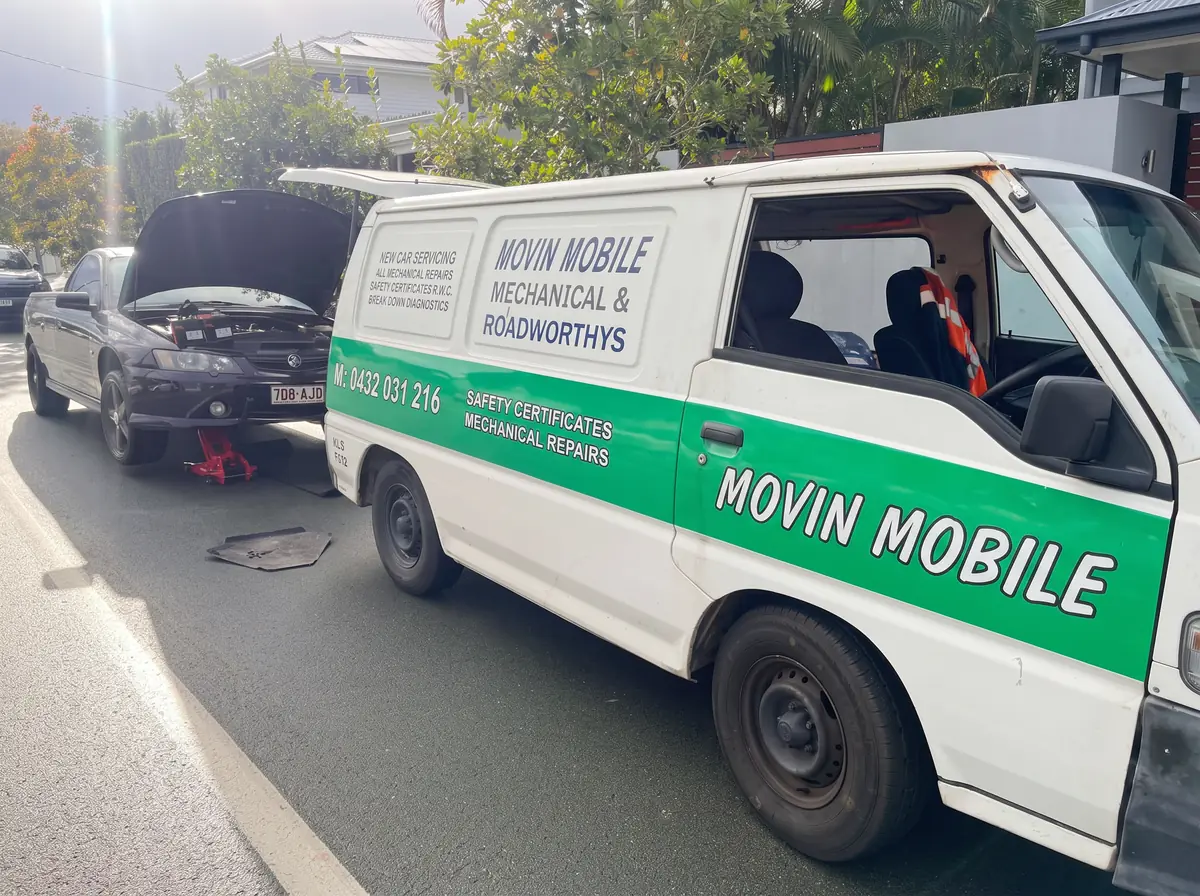 Movin Mobile van beside a car with its bonnet raised