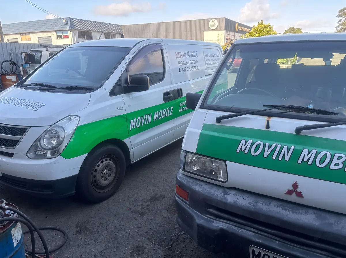 Two Movin Mobile service vans parked together outside a workshop