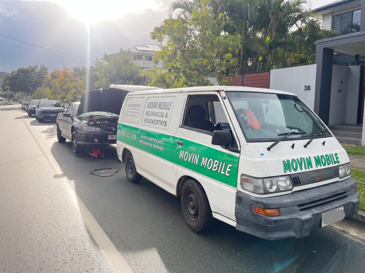 Movin Mobile service van parked beside a car on a residential street